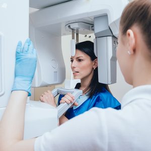 Young Woman Patient Standing In X Ray Machine.